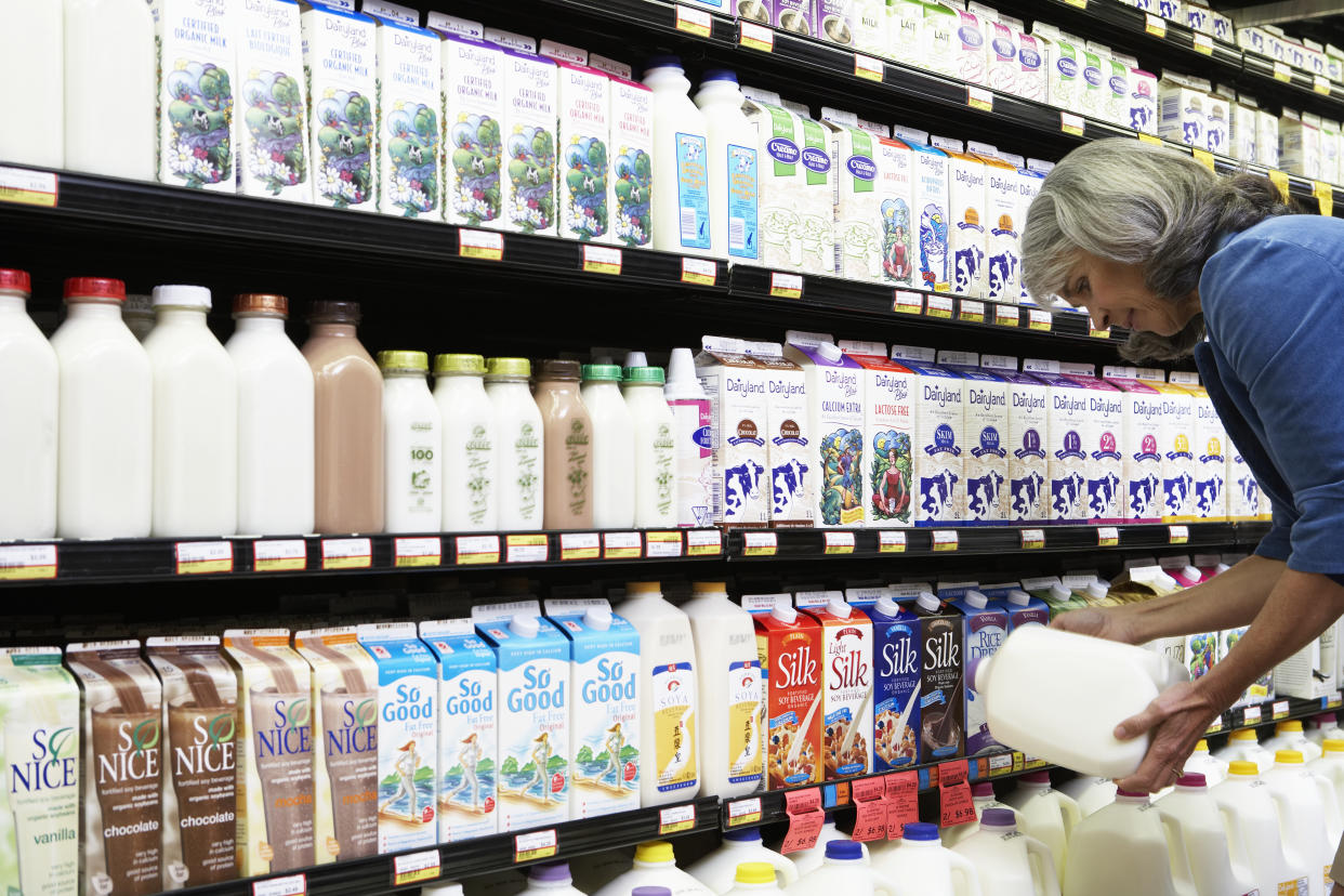 inflation price rises woman buying milk in supermarket