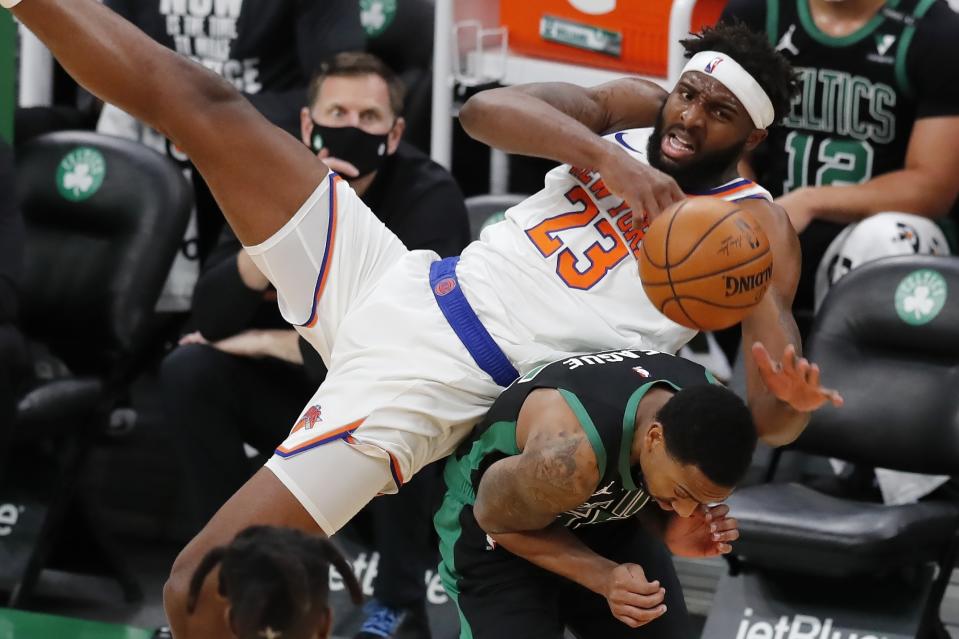 New York Knicks' Mitchell Robinson (23) falls on Boston Celtics' Jeff Teague during the first half of an NBA basketball game, Sunday, Jan. 17, 2021, in Boston. (AP Photo/Michael Dwyer)