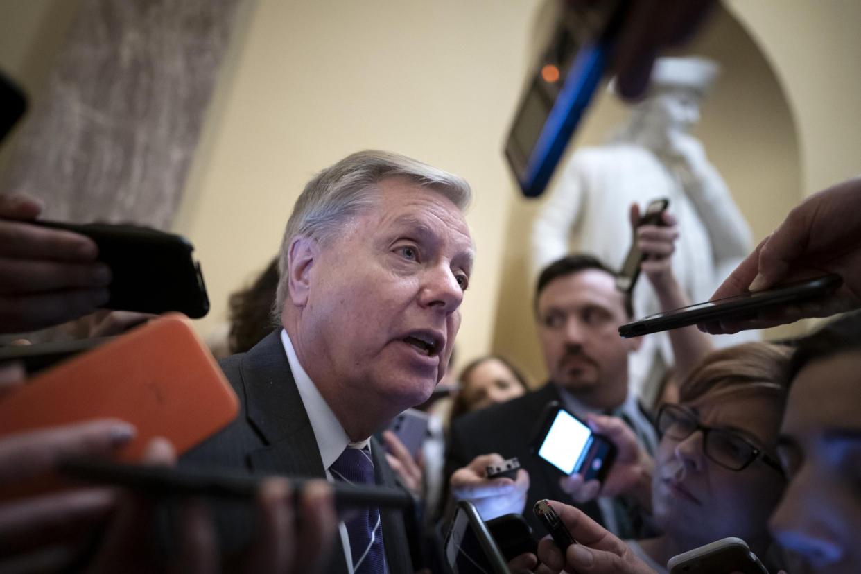 Senator Lindsey Graham surrounded by reporters on Capitol Hill: AP Photo/J. Scott Applewhite