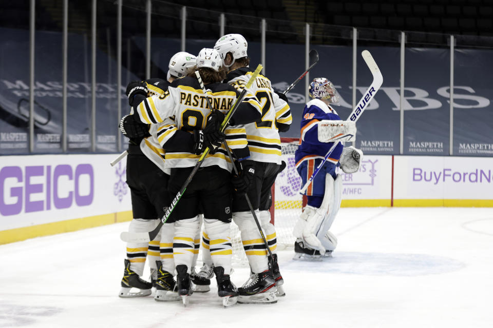 Boston Bruins center Brad Marchand is congratulated by teammates after scoring a goal against New York Islanders goaltender Semyon Varlamov during the first period of an NHL hockey game Saturday, Feb. 13, 2021, in Uniondale, N.Y. (AP Photo/Adam Hunger)