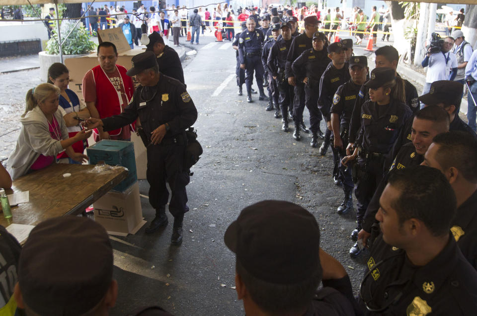 Agentes de la policía salvadoreña hacen fila para votar en las elecciones presidenciales que se disputan los candidatatos de la exguerrilla y la derechista Arena. San Salvador, domingo 9 de marzo de 2014. (AP foto/Esteban Felix)