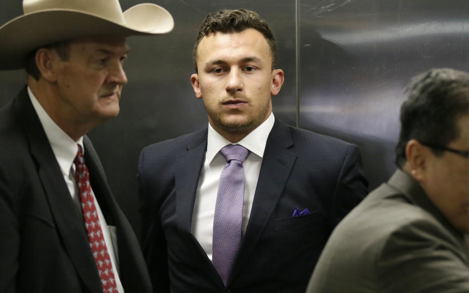 Former NFL quarterback Johnny Manziel, center, takes an elevator with his lawyer Jim Darnell, left, after a court hearing in Dallas, Tuesday, Feb. 28, 2017. A Dallas County judge ordered Manziel to be at the hearing to address concerned about reports that he has violated terms of a plea agreement for a domestic violence case. (AP Photo/LM Otero)