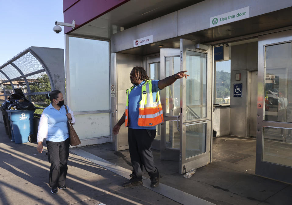 A CTA employee informs commuters that the 63rd St. CTA Red Line station in closed following an early morning fatal stabbing on a CTA train in Chicago, Monday, July 25, 2022. (Antonio Perez/Chicago Tribune via AP)