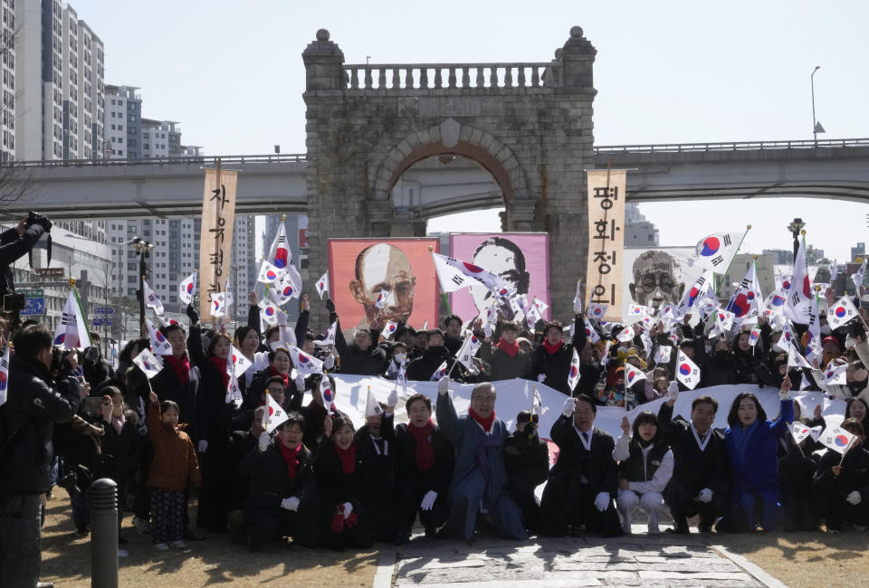 South Koreans wave their national flags during a ceremony to celebrate the March First Independence Movement Day, the anniversary of the 1919 uprising against Japanese colonial rule, in front of the Independence Gate in Seoul, South Korea, Friday, March 1, 2024. (AP Photo/Ahn Young-joon)