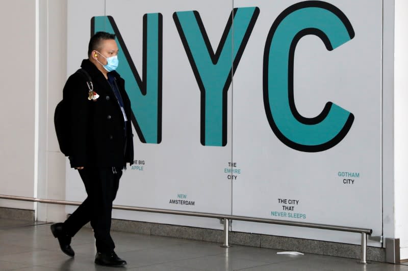 Travelers wear face masks as they arrive at John F. Kennedy International Airport in New York