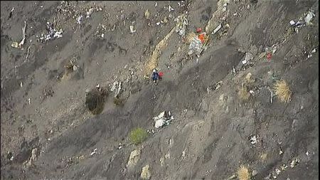 French gendarmes and rescue crew make their way around debris from an Airbus A320 in the mountains, near Seyne-les-Alpes, March 24, 2015 in this still image taken from TV. REUTERS via Reuters TV/Pool