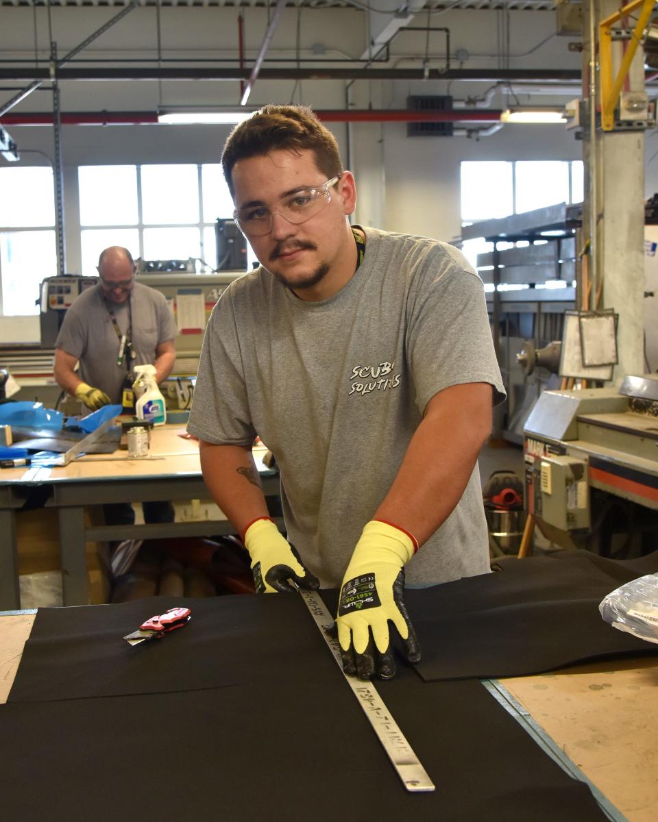 Sheet metal mechanic Matthew Gaudreau makes a measurement on a piece of foam for use in a shipboard locker at Portsmouth Naval Shipyard Wednesday, Aug. 24, 2022. Gaudreau is one of 243 graduating this year from the Trades and Worker Skills Progression Program.
