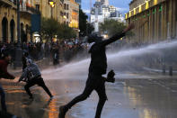 Anti-government protesters throw stones at the riot police during ongoing protests in Beirut, Lebanon, Wednesday, Jan. 22, 2020. Lebanon's new government has held its first meeting a day after it was formed following a three-month political vacuum. (AP Photo/Bilal Hussein)