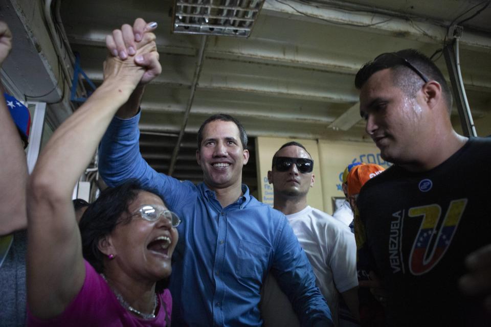 Venezuela's opposition leader and self-proclaimed Interim President Juan Guaido, center, greets merchants at the Free Market in Maracay, Aragua's State, Saturday, August 31, 2019. Venezuelan officials say they have proof of paramilitary training camps operating in neighboring Colombia where groups are plotting attacks to undermine President Nicolas Maduro. (AP Photo/Andrea Hernandez)