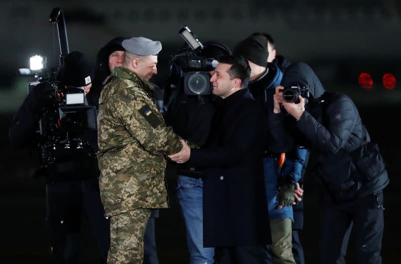 Ukraine's President Zelenskiy greets citizens exchanged during a prisoners of war swap at an airport outside Kiev