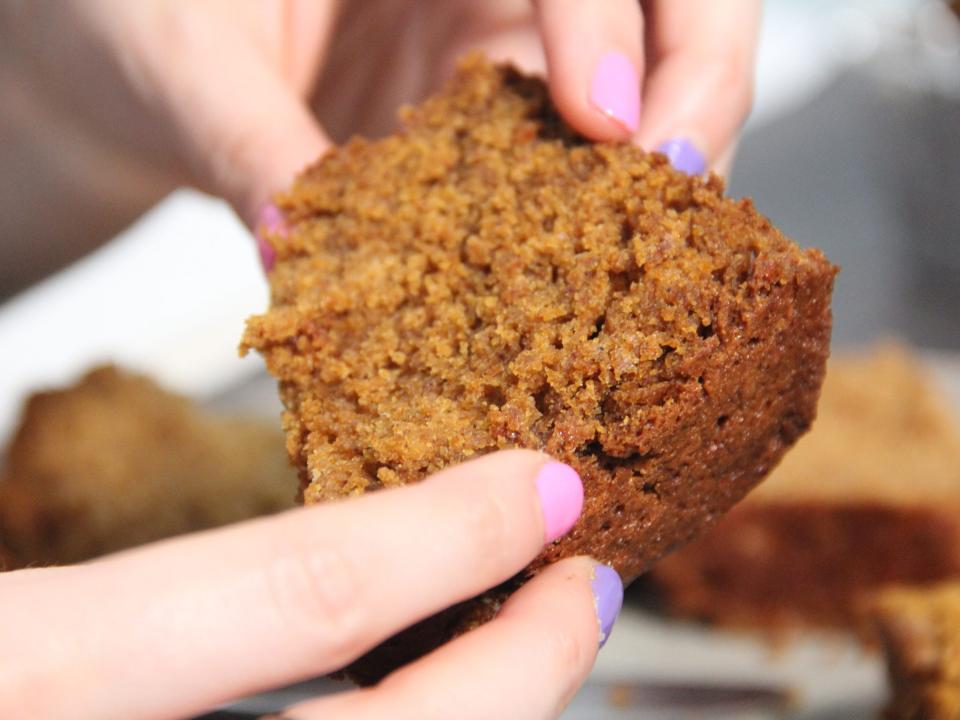 Holding a slice of pumpkin bread with two hands.