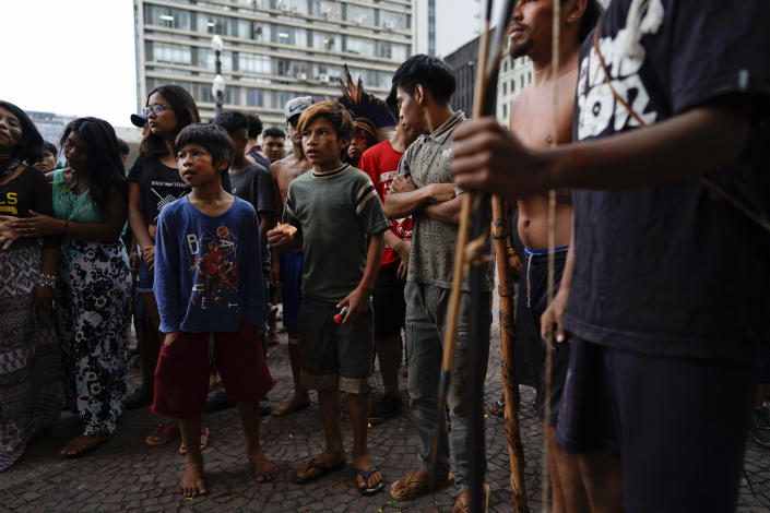 FILE - In this March 27, 2018, file photo, Indigenous people stand outside Sao Paulo's City Hall during a demonstration. On Friday, Oct. 22, The Associated Press reported on stories circulating online incorrectly asserting that a video showed aboriginal people in Australia defending themselves with bows and arrows against authorities trying to forcibly administer COVID-19 vaccines. In fact, the video showed a group of Guarani Indigenous people in Sao Paulo, Brazil, demonstrating against health care policy changes in March 2019. (AP Photo/Victor R. Caivano)