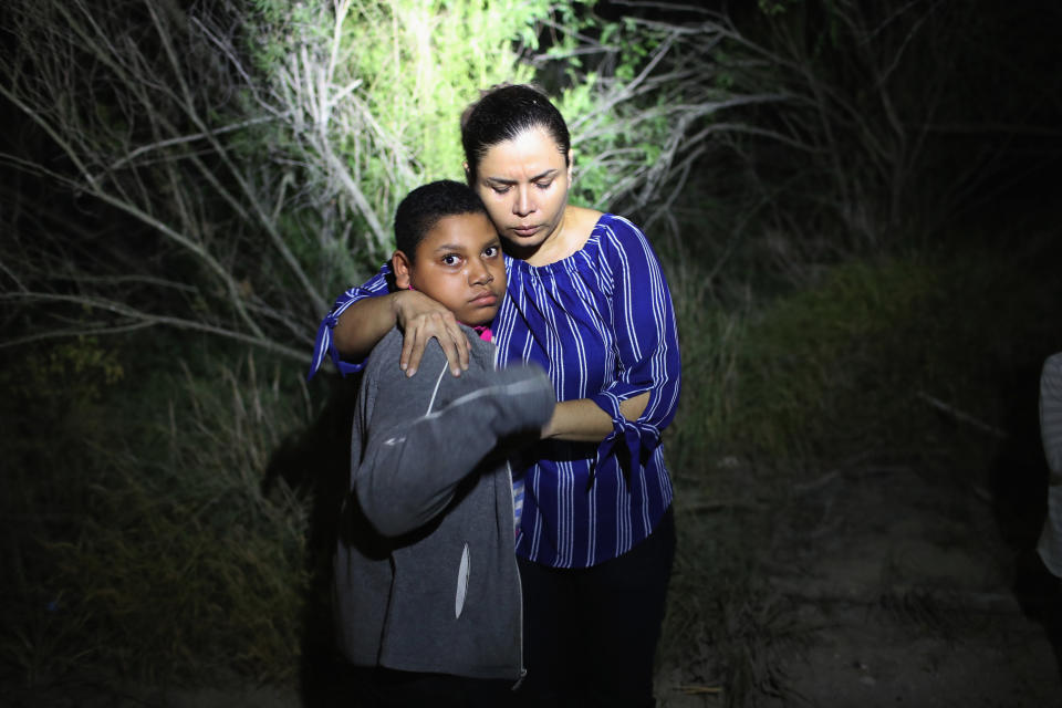 A U.S. Border Patrol spotlight shines on a mother and son from Honduras on June 12, 2018, in McAllen, Texas.