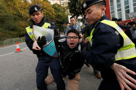 A pro-democracy protester against the disqualification of lawmakers is taken away by the police before Hong Kong Chief Executive Carrie Lam arrives to vote during a Legislative Council by-election in Hong Kong, China March 11, 2018. REUTERS/Bobby Yip