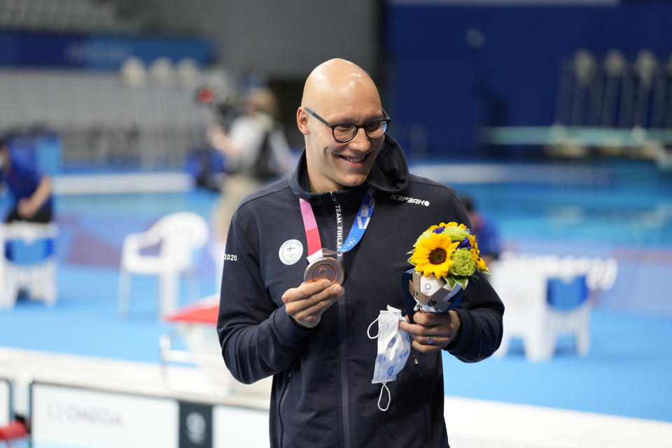 Matti Mattsson holds flowers and bronze medal