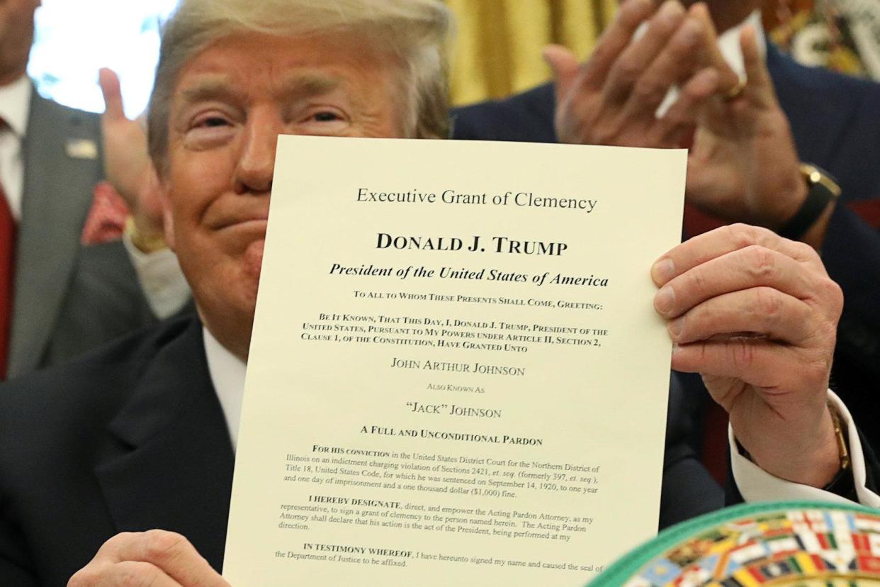 U.S. President Donald Trump holds up the pardon he signed for the late Jack Johnson: REUTERS/Kevin Lamarque