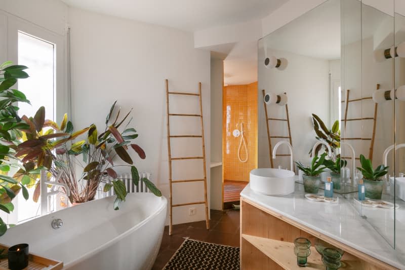 Soaking tub in plant filled bathroom.