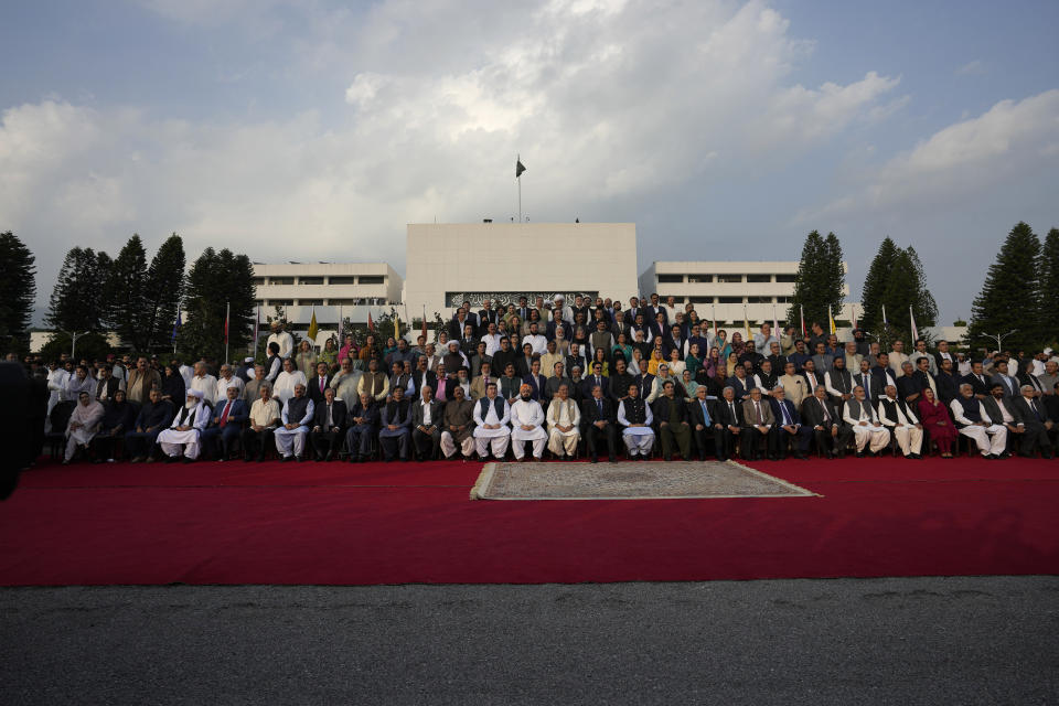 Pakistan's Prime Minister Shehbaz Sharif, center, poses for a group photo with lawmakers of the National Assembly at the end of the last session of the current parliament, in Islamabad, Pakistan, Wednesday, Aug. 9, 2023. Pakistan's prime minister took a formal step Wednesday toward dissolving parliament, starting a possible countdown to a general election, as his chief political rival fought to overturn a corruption conviction that landed him in a high-security prison over the weekend. (AP Photo/Anjum Naveed)