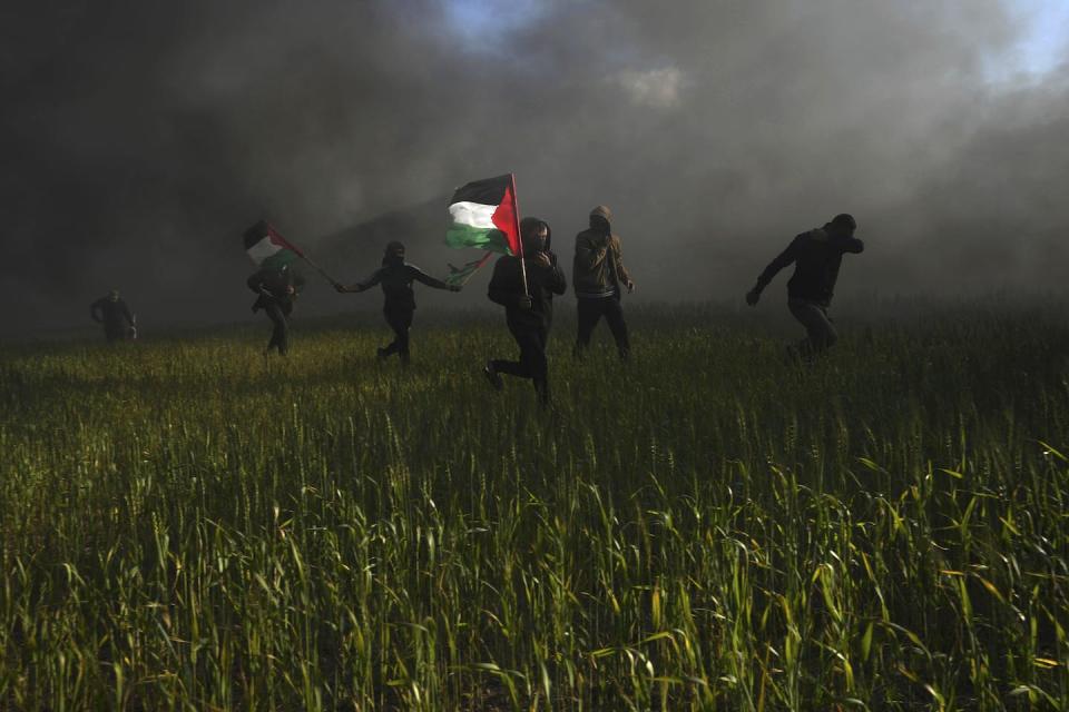 A person waves the Palestinian flag during a protest against an Israeli military raid in the West Bank city of Nablus in February 2022. (AP Photo/Adel Hana)