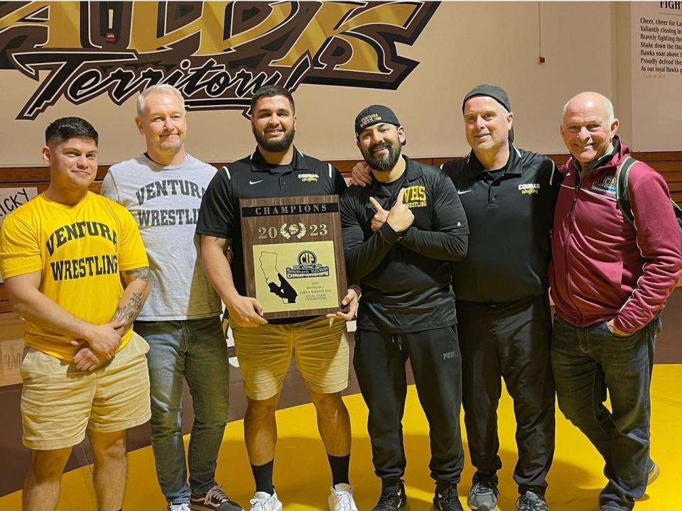 Ventura High girls wrestling coaches pose with the championship plaque after the Cougars defeated host Laguna Hills 47-30 to win the CIF-Southern Section Division 2 team dual title Wednesday night.