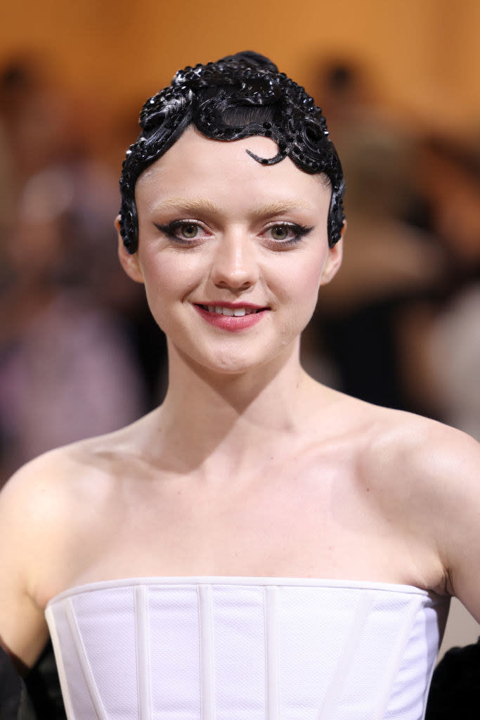 A closeup of Maisie Williams with a '20s-style headpiece