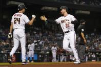 Arizona Diamondbacks' Pavin Smith (26) and Luke Weaver (24) celebrate their runs scored against the Miami Marlins during the third inning of a baseball game Monday, May 10, 2021, in Phoenix. (AP Photo/Ross D. Franklin)