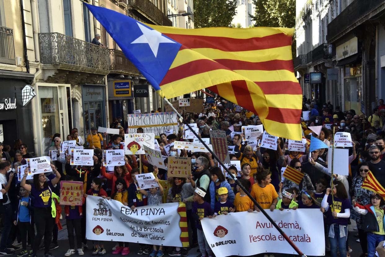 Des manifestants brandissent des drapeaux catalans et tiennent des bannières de l'association catalane La Bressola lors d'un rassemblement contre le projet de la mairie d'acquérir le Couvent Sainte-Claire à Perpignan, dans le sud de la France, le 23 octobre 2021.  - RAYMOND ROIG / AFP