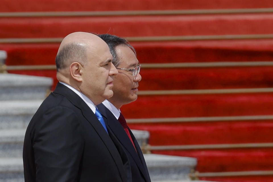 Russian Prime Minister Mikhail Mishustin, left, and Chinese Premier Li Qiang attend a welcoming ceremony in Beijing, China Wednesday, May 24, 2023. (Thomas Peter/Pool Photo via AP)