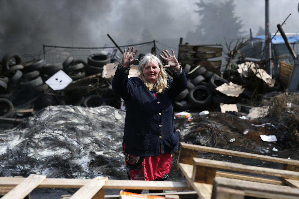 <p>A woman raises her hands as trade unionists erect a burning barricade at a refinery to protest a French labor reform law, in Douchy les Mines, northern France, on May 24, 2016. (Thibault Vandermersch/EPA) </p>