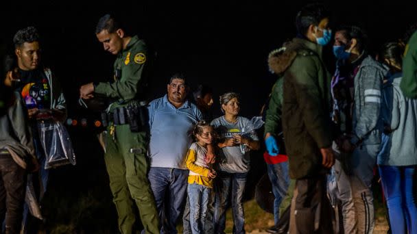 PHOTO: A migrant family stands waiting to be processed at the border, May 5, 2022, in Roma, Texas.  (Brandon Bell/Getty Images)