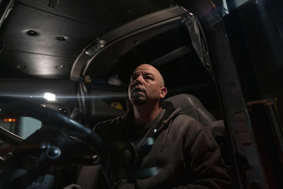 In this April 7, 2020, photo, trucker Sammy Lloyd, of Ringgold, Ga., pauses after climbing into the cab of his semitruck before leaving Love's Travel Stop truck stop in Greenville, Va., before dawn, as he hauls a COVID-19 emergency relief load from California to a Target Distribution Center in Stuarts Draft, Va. (AP Photo/Carolyn Kaster)