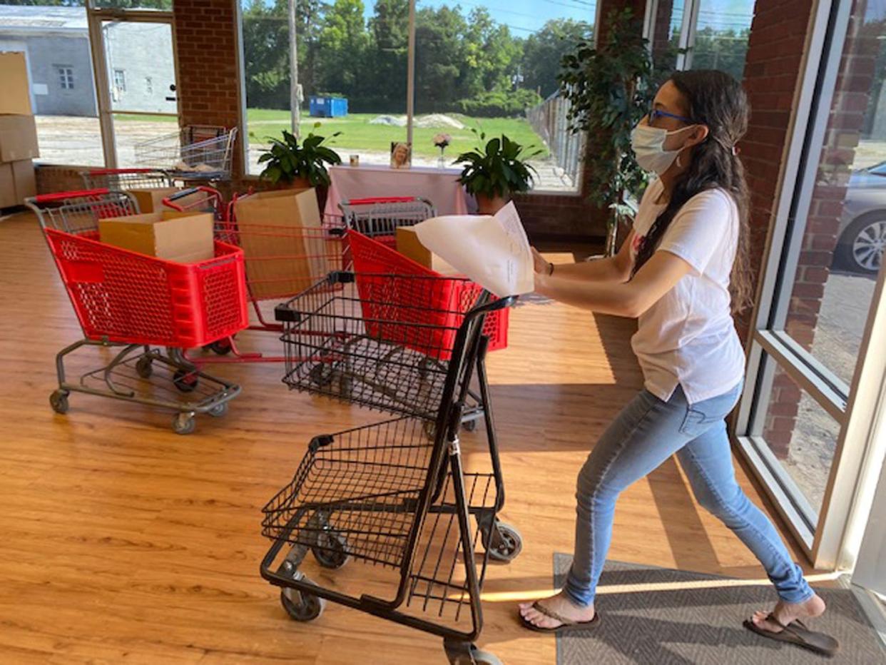 Raven Hammonds, a part-time employee at Robeson County Church and Community Center,
helps operate the organization’s food pantry.