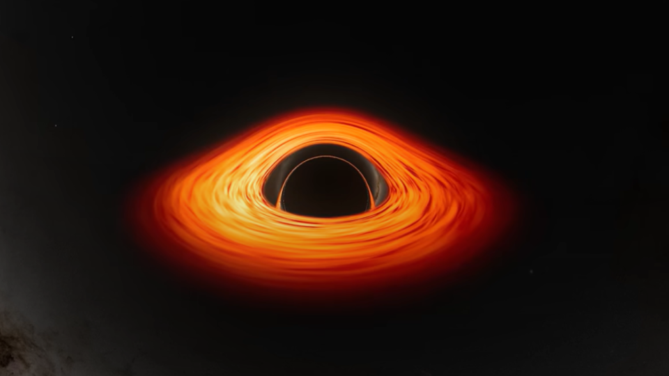 a series of spaghetti-like orange rings surround a black sphere