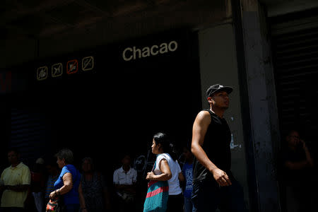 People walk past a closed metro station during a blackout in Caracas, Venezuela March 25, 2019. REUTERS/Carlos Garcia Rawlins
