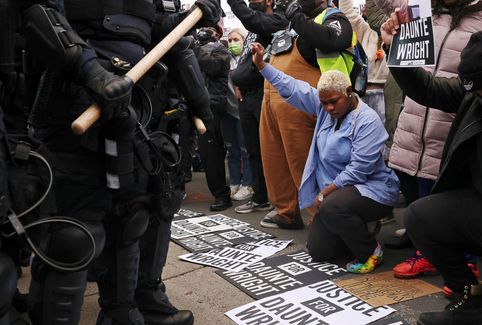 Image: Evelyn Jarbah kneels as protesters take a moment of silence during a rally outside Brooklyn Center Police Department, a day after Daunte Wright was shot and killed by a police officer, in Brooklyn Center, Minn. (Leah Millis / Reuters)