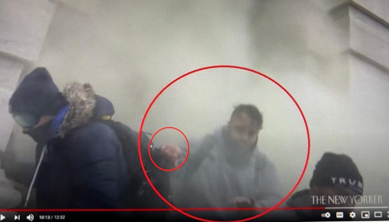 Anthony Sargent is seen exiting the Capitol building through a cloud of white smoke on Jan. 6, 2021, according to the federal prosecutors. The smaller red circle indicates tattoos on his knuckles and hand, according to prosecutors.