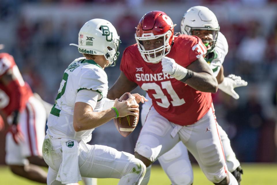 Baylor’s Blake Shapen (12) looks to pass as Oklahoma’s Jalen Redmond (31) makes a sack during a college football game between the University of Oklahoma Sooners (OU) and the Baylor Bears at Gaylord Family - Oklahoma Memorial Stadium in Norman, Okla., Saturday, Nov. 5, 2022.