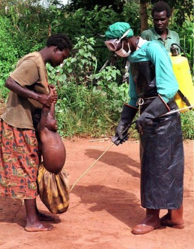 A worker from St Mary's Lacor hospital disinfects villagers during an earlier Ebola outbreak in Uganda. Seven doctors and 13 health workers at Kampala's Mulago hospital are in quarantine after "at least one or two cases" were taken there, with one later dying from the virus