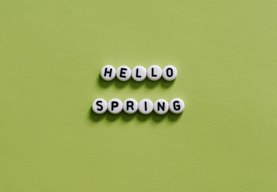 hello spring text message on light green background lettering