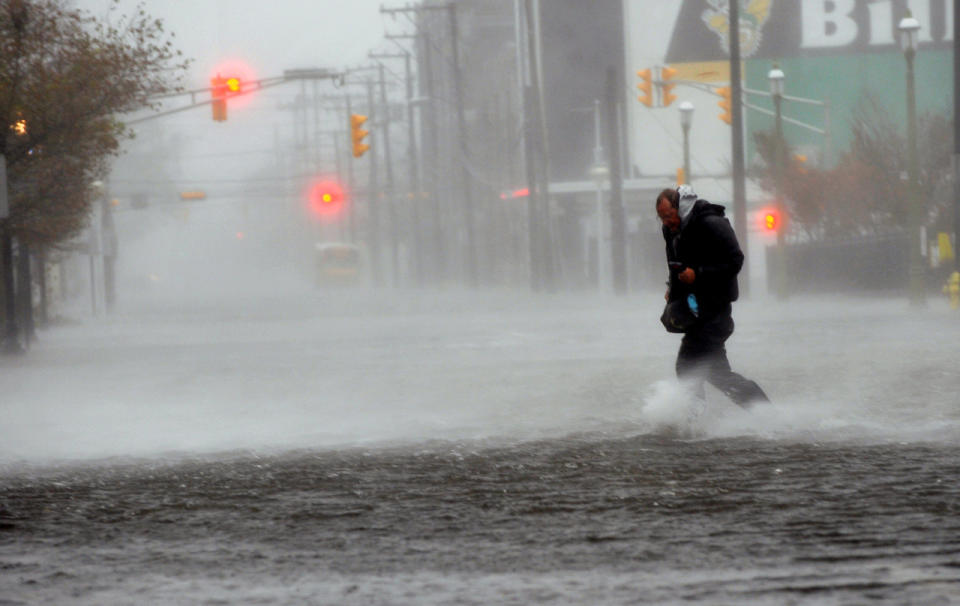 Michael Wirtz, of Wilmington, Del., braves flood waters and high winds that arrive with Hurricane Sandy along North Michigan Avenue in Atlantic City, N.J., Monday Oct. 29, 2012. Hurricane Sandy continued on its path Monday, forcing the shutdown of mass transit, schools and financial markets, sending coastal residents fleeing for higher ground, and threatening a dangerous mix of high winds and soaking rain. (AP Photo/The Press of Atlantic City, Michael Ein) MANDATORY CREDIT