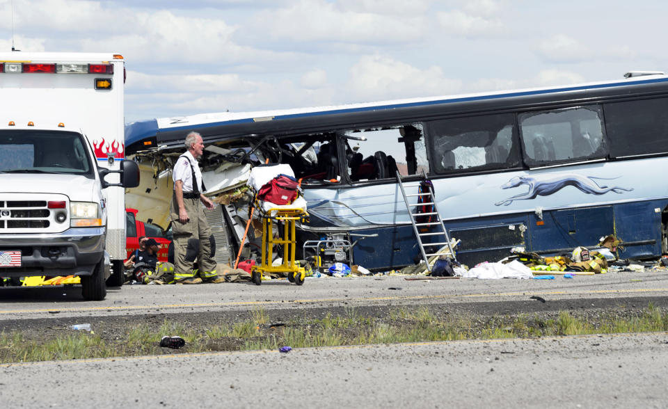 This Thursday, Aug. 30, 2018 photo shows a firefighter at the scene of the collision of a semitrailer that crossed the median of Interstate 40 and crashed head-on into a Greyhound bus near Thoreau, N.M. A California-based trucking company and one of its drivers were accused of negligence Friday in a pair of lawsuits as investigators sorted through the wreckage of the deadly bus crash along a New Mexico highway. (Brandon N. Sanchez/Gallup Independent via AP)