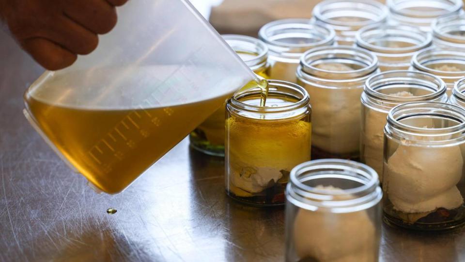Arturo Ramirez pours olive oil into a jar of Marinated Fromage Blanc, lactic cow’s milk cheese, Olea Farm olive oil, black peppercorns, bay leaf and chili at the family-owned Stepladder Ranch off of San Simeon Creek Road north of Cambria.