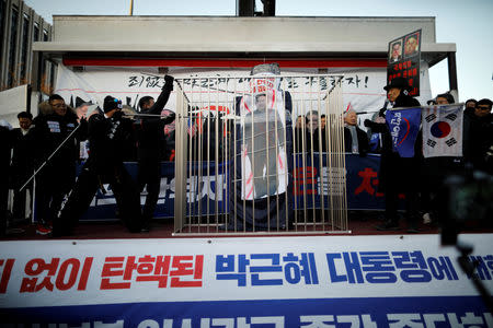 Members of a South Korean conservative civic group deface a banner with the image of North Korean leader Kim Jong Un during an anti-North Korea protest in Seoul, South Korea, December 8, 2018. Picture taken December 8, 2018. REUTERS/Kim Hong-Ji