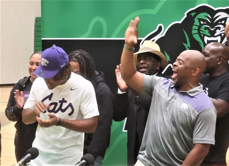 Dylan Edwards, left, announces his commitment to Kansas State, while his father Leon, a himself a former Wildcat running back, celebrates Thursday at Derby High School.