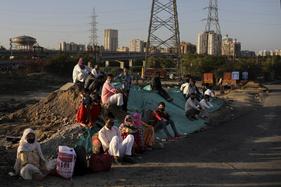 A group of Indian migrant workers rest as they wait for transportation to their village following a lockdown amid concern over spread of coronavirus in New Delhi, India, Saturday, March 28, 2020. Authorities sent a fleet of buses to the outskirts of India's capital on Saturday to meet an exodus of migrant workers desperately trying to reach their home villages during the world's largest coronavirus lockdown. Thousands of people, mostly young male day laborers but also families, fled their New Delhi homes after Prime Minister Narendra Modi announced a 21-day lockdown that began on Wednesday and effectively put millions of Indians who live off daily earnings out of work. (AP Photo/Altaf Qadri)