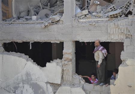 A man and boys inspect a site hit by what activists said was shelling by forces loyal to Syria's President Bashar al-Assad, in the Duma neighbourhood of Damascus September 4, 2013. REUTERS/Bassam Khabieh