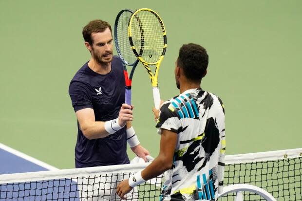 Felix Auger-Aliassime, of Canada, right, taps rackets with Andy Murray, of Great Britain, during the third round of the U.S. Open in 2020. The Canadian has drawn the two-time Olympic gold medallist in the first round of the Tokyo 2020 tournament. (Frank Franklin II/The Associated Press - image credit)