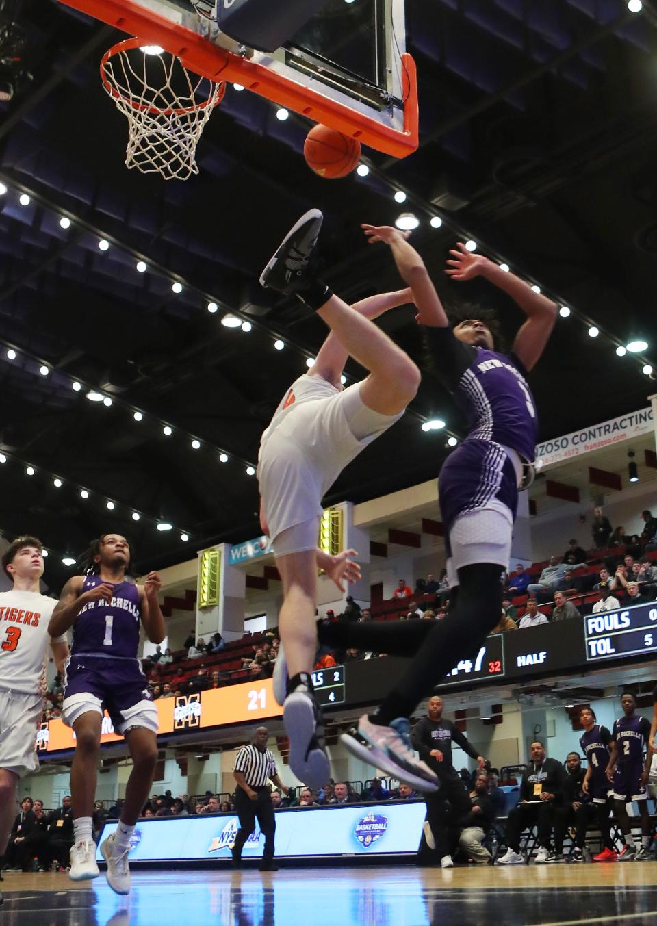 New Rochelle's Malik Gasper (3) gets fouled by Mamaroneck's Will Plunket (15) as he goes up for a shot during the Section 1 Class AAA semifinal at the Westchester County Center in White Plains Feb. 28, 2024. New Rochelle won the game in overtime 52-50.