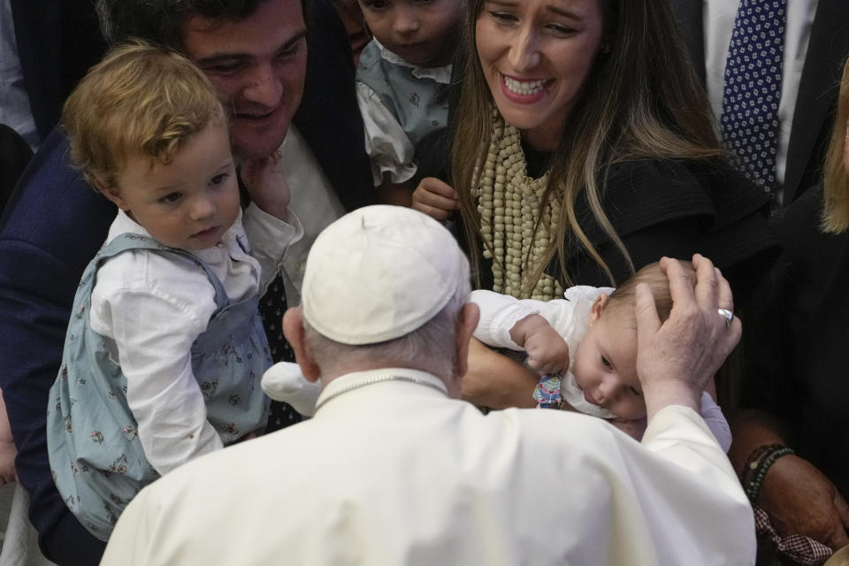 Pope Francis caresses a baby during his weekly general audience in the Pope Paul VI hall at the Vatican, Wednesday, Aug. 30, 2023. (AP Photo/Andrew Medichini)