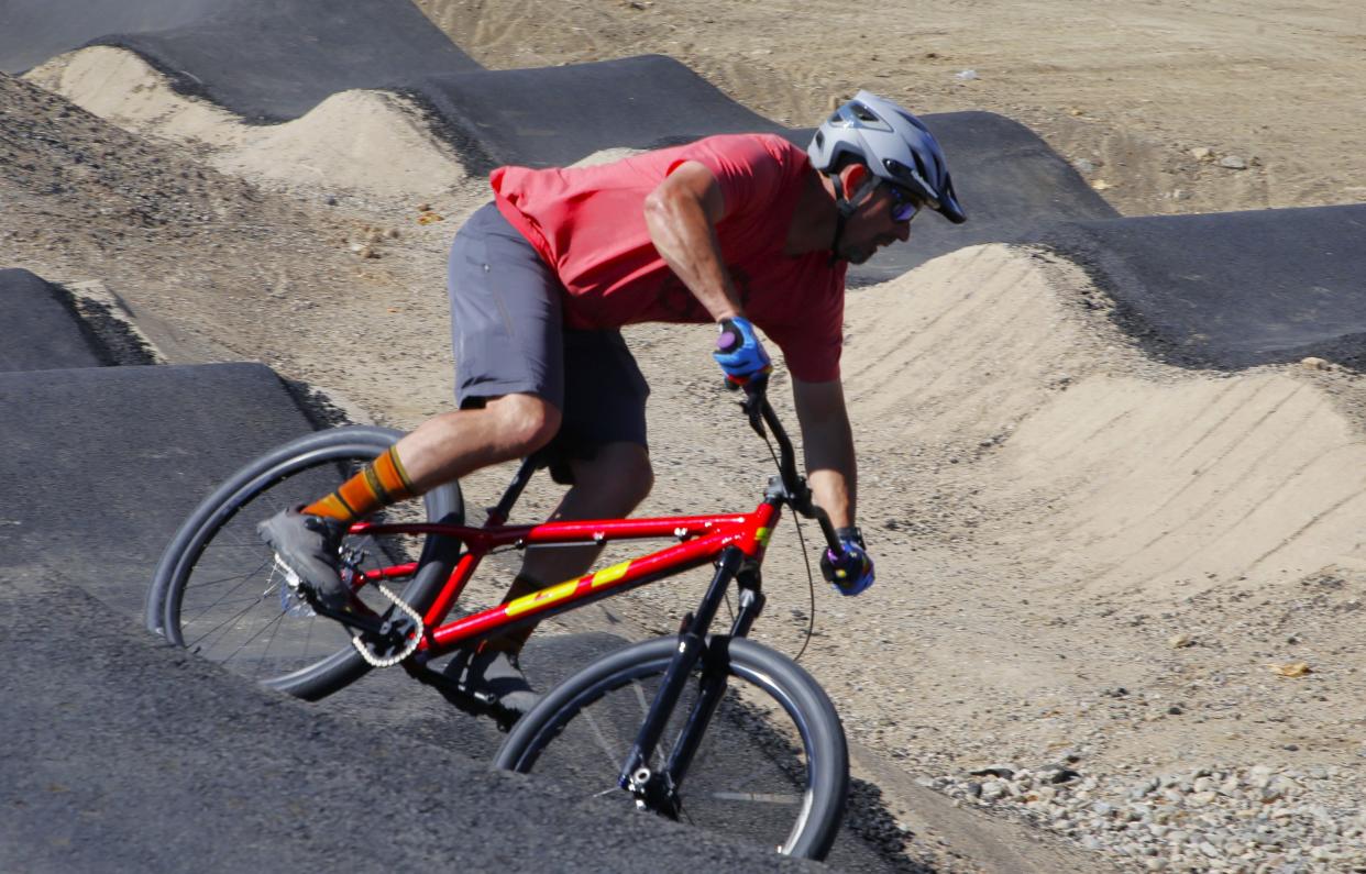 Chris Conley, the president of Farmington Area Single Track, glides into a banked turn at the new pump track at the San Juan College Bike Park on Wednesday, April 17 south of the college campus in Farmington.